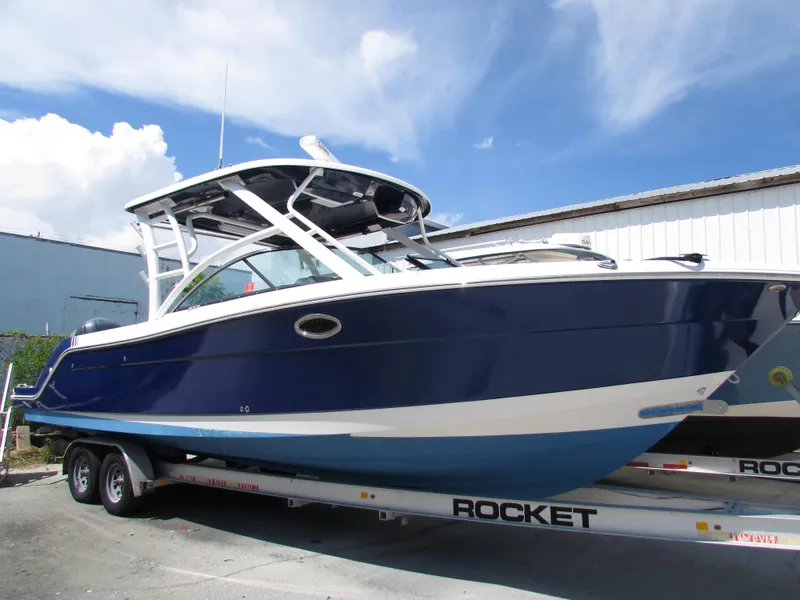 The Image of 2017 Robalo 317 boat on trailer under blue sky. - 1