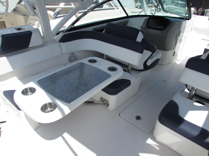 Slide: The Image of 2017 Robalo 317 boat interior with seating and table, featuring cup holders. - 6