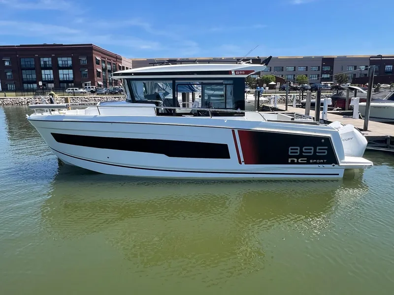 The Image of 2025 Jeanneau NC 895 Sport S2 boat docked in a marina, side view. - 0