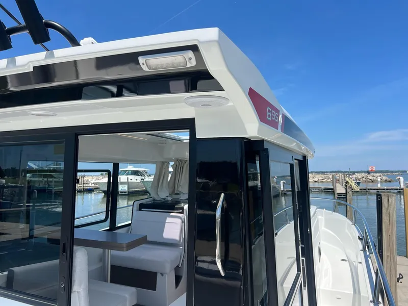 Slide: The Image of 2025 Jeanneau NC 895 Sport S2 boat docked, showcasing sleek design and spacious interior. - 10