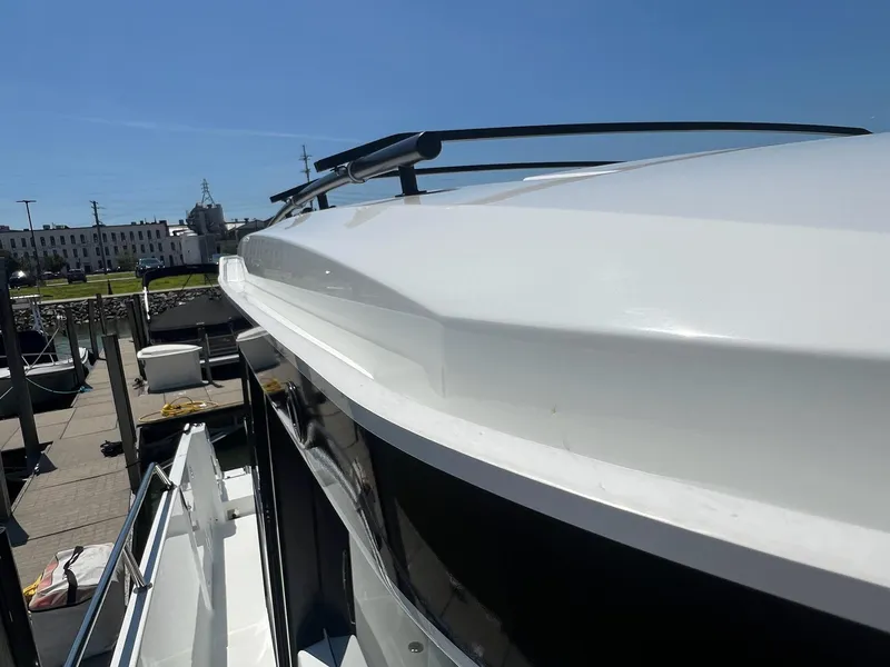 Slide: The Image of 2025 Jeanneau NC 895 Sport S2 boat docked under clear blue sky. - 18