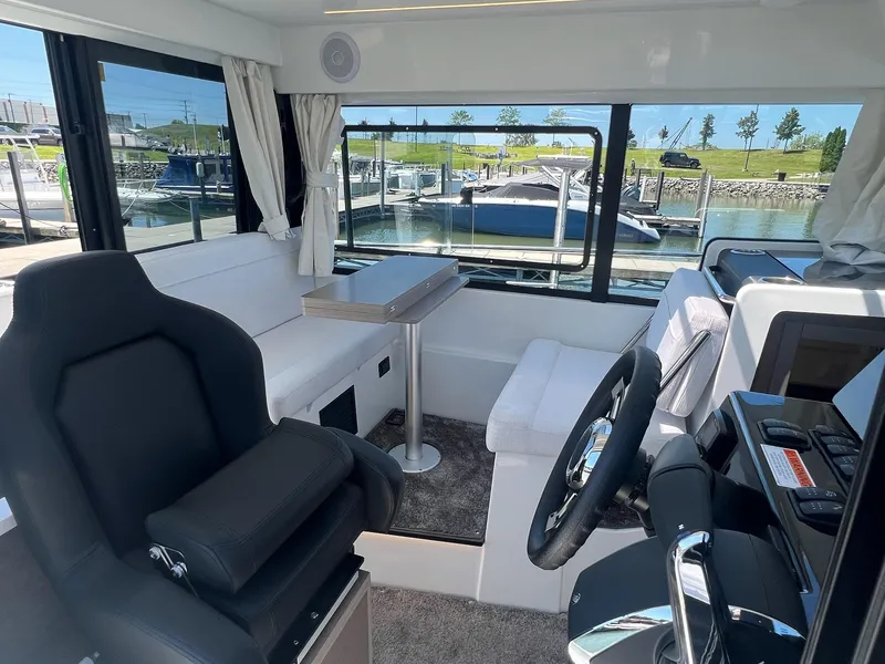Slide: The Image of Interior of 2025 Jeanneau NC 895 Sport S2 boat, featuring seating and steering area. - 19