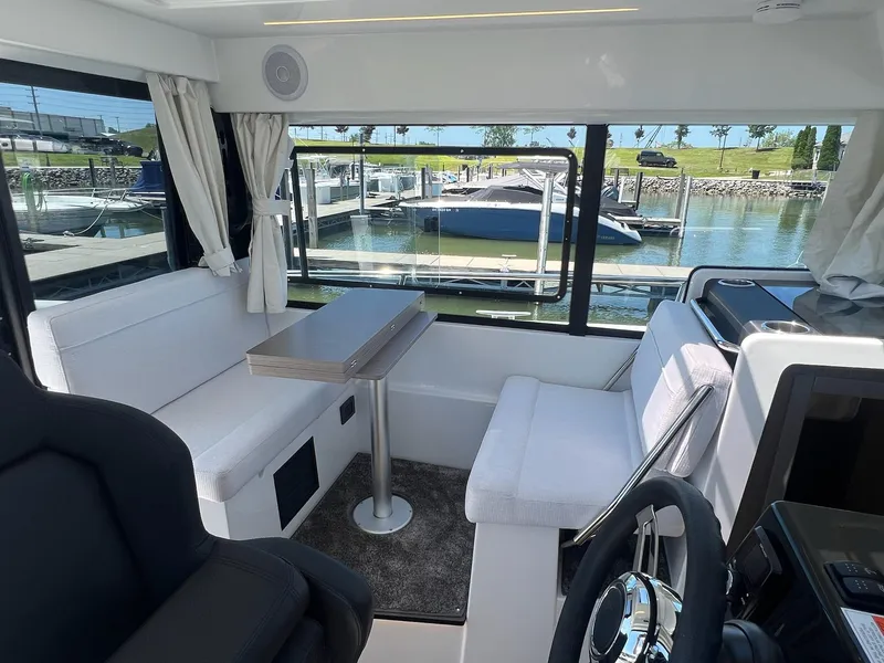 Slide: The Image of Interior of 2025 Jeanneau NC 895 Sport S2 boat with seating and table by marina. - 20