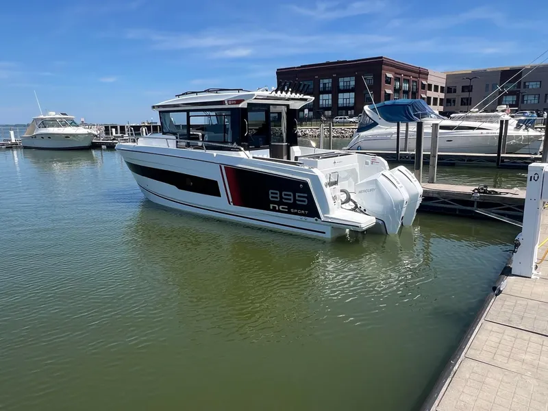 Slide: The Image of 2025 Jeanneau NC 895 Sport S2 boat docked at marina under clear blue sky. - 3