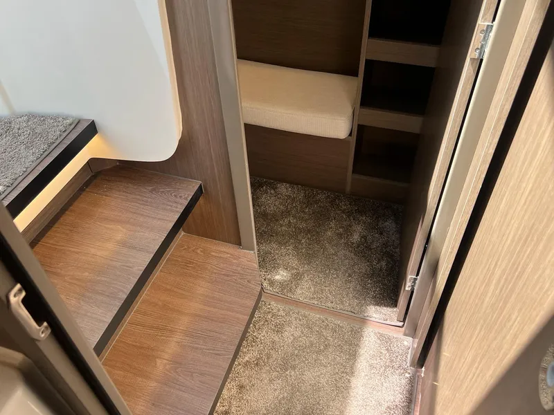Slide: The Image of Interior of 2025 Jeanneau NC 895 Sport S2, featuring wooden steps and carpeted flooring. - 32