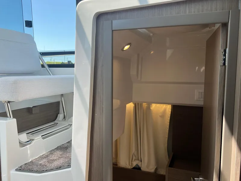 Slide: The Image of Interior view of 2025 Jeanneau NC 895 Sport S2, featuring seating and cabin entrance. - 33