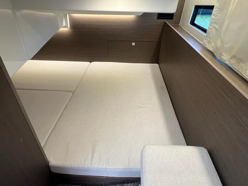 Slide: The Image of 2025 Jeanneau NC 895 Sport S2 cabin interior with cozy bed and window view. - 34