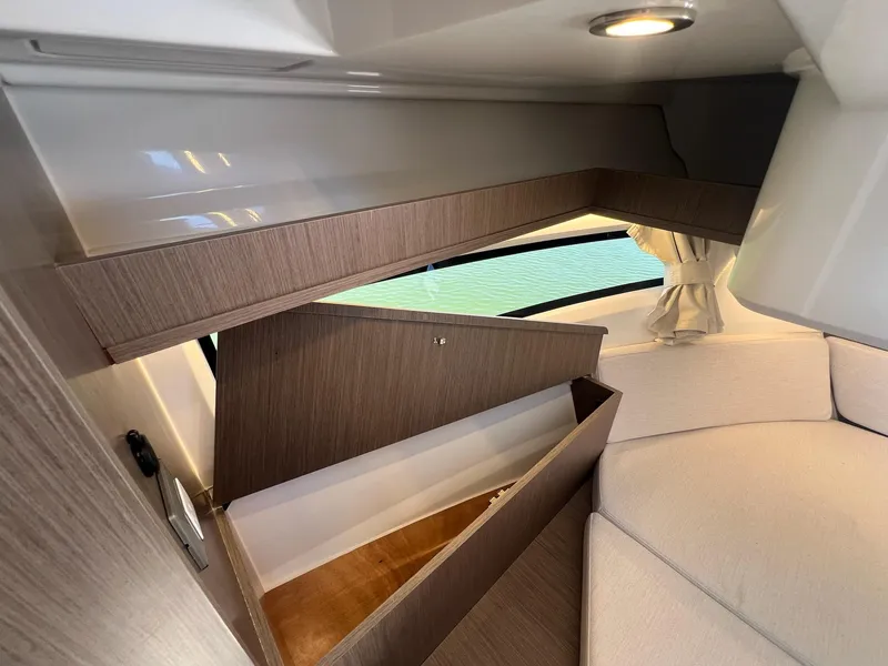 Slide: The Image of Interior of 2025 Jeanneau NC 895 Sport S2, featuring modern wood paneling and seating. - 46