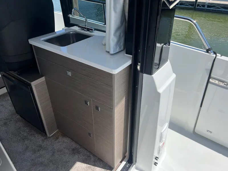 Slide: The Image of Compact kitchenette on 2025 Jeanneau NC 895 Sport S2 boat, featuring sink and storage. - 6