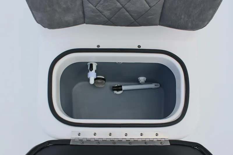 Slide: The Image of Livewell compartment in 2026 Avid 19 FSX boat, featuring a gray interior and plumbing components. - 52