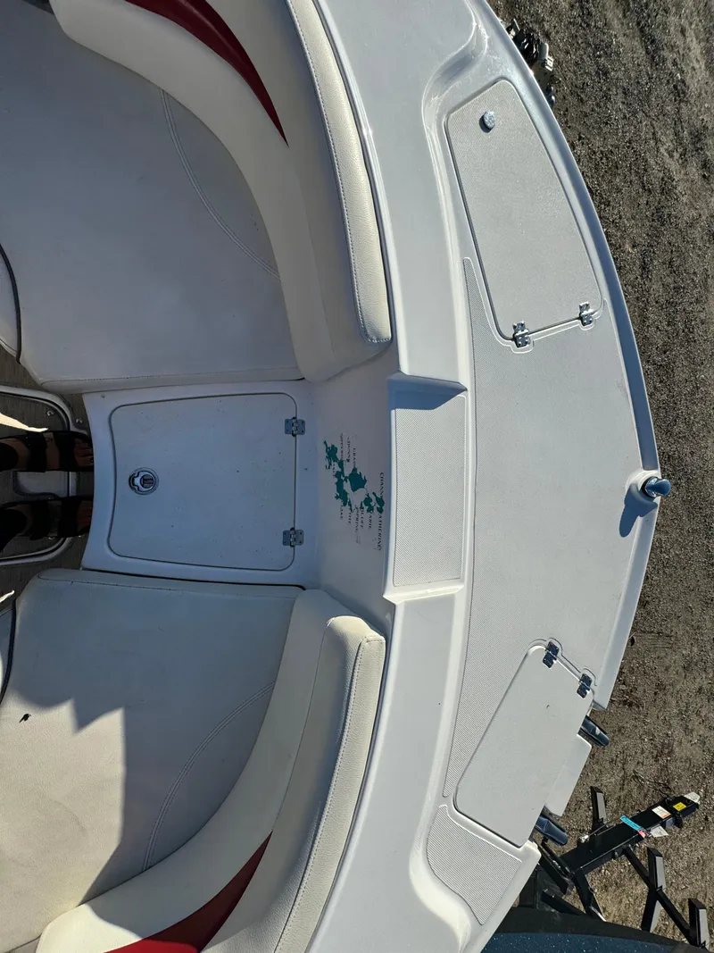 Slide: The Image of 2013 Hurricane SS 203 OB boat interior with white seating and storage compartments. - 16
