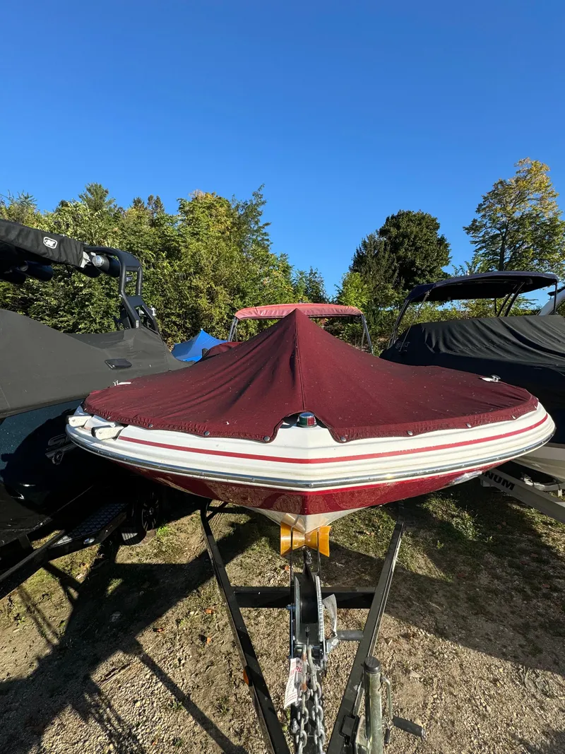 Slide: The Image of 2013 Hurricane SS 203 OB boat with maroon cover on trailer, outdoors. - 18
