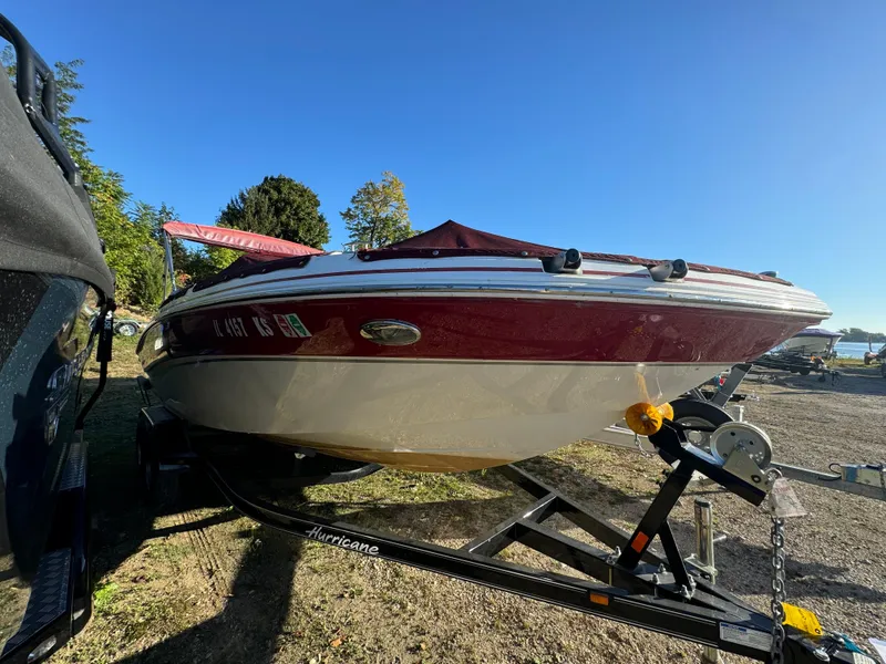 Slide: The Image of 2013 Hurricane SS 203 OB boat on trailer, parked outdoors under clear blue sky. - 19