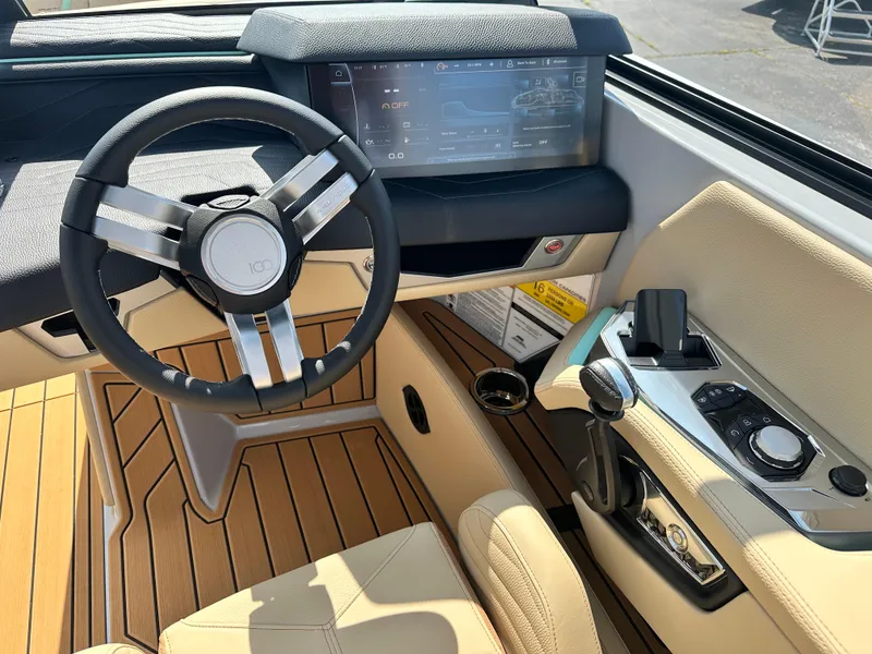 Slide: The Image of 2025 Nautique G23 boat cockpit with modern steering wheel and digital dashboard. - 16