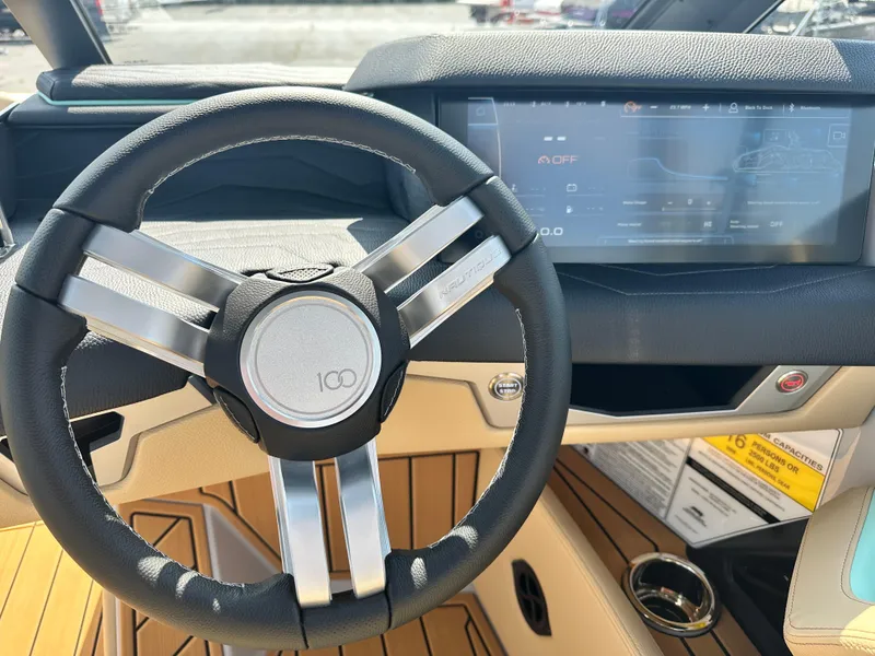 Slide: The Image of 2025 Nautique G23 steering wheel and dashboard with modern touchscreen display. - 17