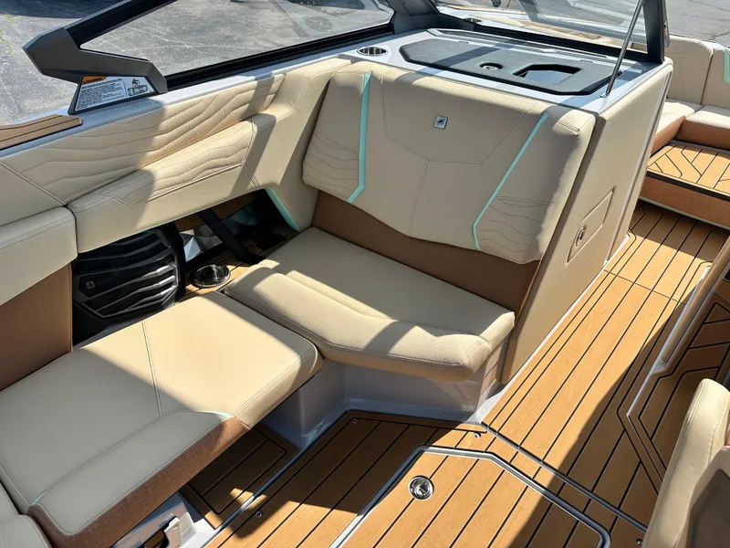 Slide: The Image of 2025 Nautique G23 boat interior with beige seating and teak flooring. - 18