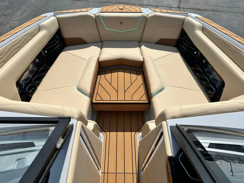 Slide: The Image of 2025 Nautique G23 boat interior with luxurious seating and teak flooring. - 19