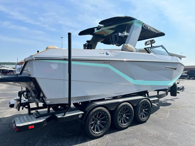 Slide: The Image of 2025 Nautique G23 boat on trailer, sleek design, parked outdoors. - 5