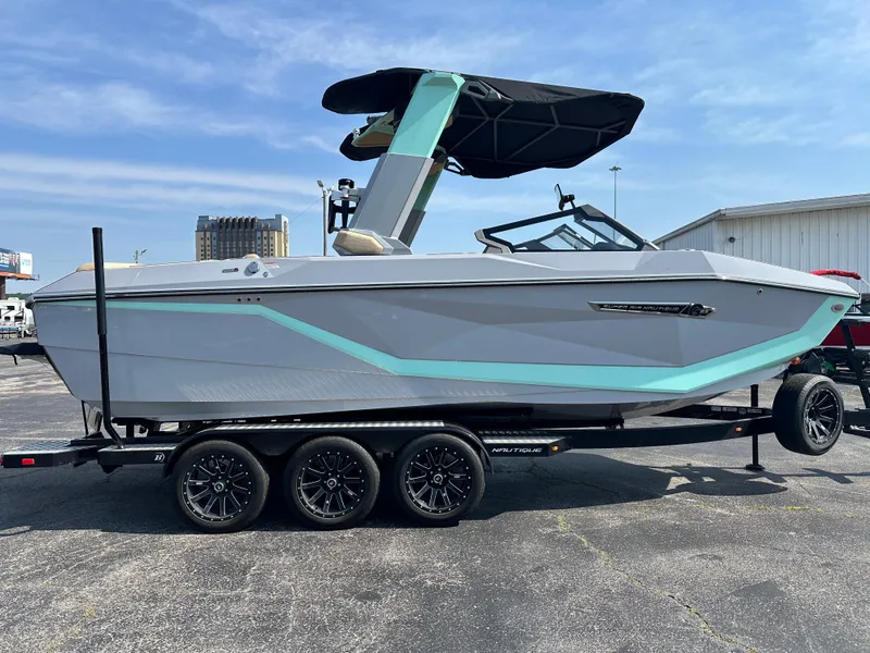 Slide: The Image of 2025 Nautique G23 boat on trailer, sleek design, light blue accents, black canopy. - 7