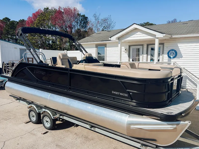 Slide: The Image of 2025 Godfrey Sweetwater 22' Flip Lounge Tritoon on trailer, parked outside a building. - 14