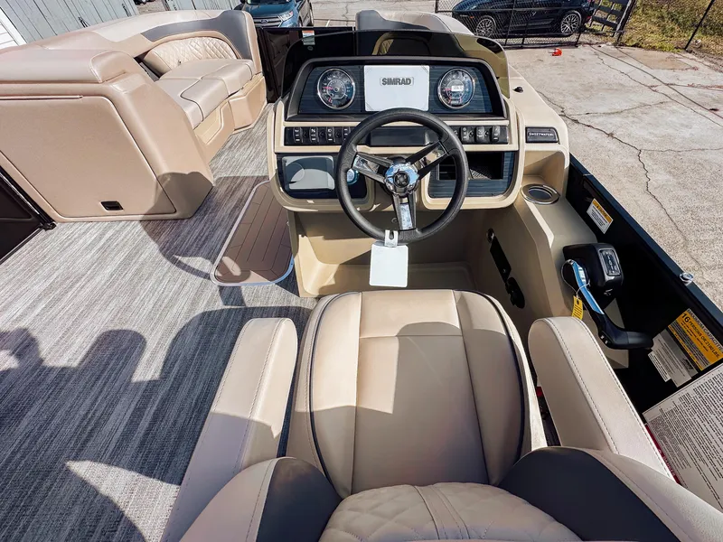 Slide: The Image of 2025 Godfrey Sweetwater 22' Flip Lounge Tritoon interior with steering wheel and seating. - 22