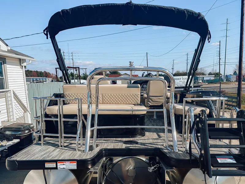 Slide: The Image of 2025 Godfrey Sweetwater 22' Flip Lounge Tritoon with seating and canopy, docked outdoors. - 27