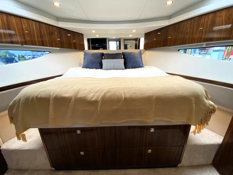 Slide: The Image of Luxurious bedroom interior of 2025 Riviera 465 SUV yacht with elegant wood finishes. - 13
