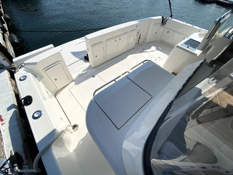 Slide: The Image of 2025 Riviera 465 SUV boat deck, spacious and modern design, docked by the water. - 14