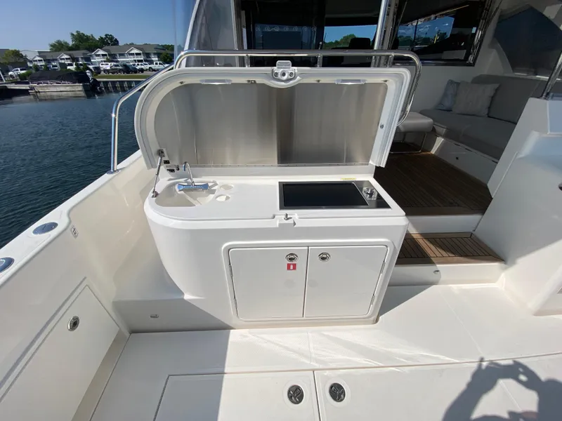 Slide: The Image of Outdoor kitchenette on 2025 Riviera 465 SUV yacht, featuring sink and stove. - 16