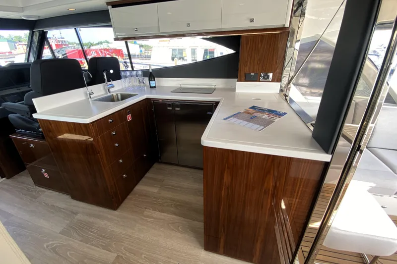 Slide: The Image of Luxurious kitchen interior of 2025 Riviera 465 SUV yacht with modern wood cabinetry. - 21