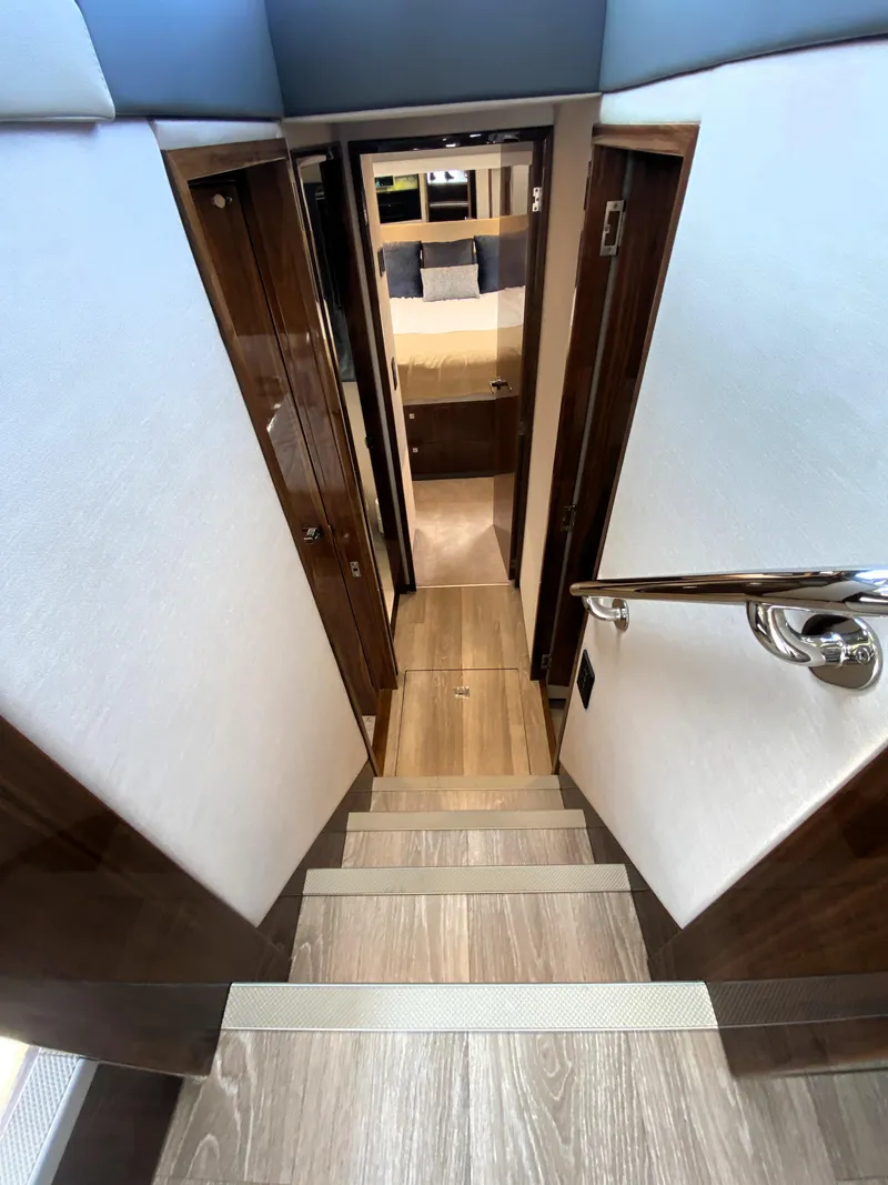 Slide: The Image of Interior staircase of 2025 Riviera 465 SUV yacht, leading to a cozy cabin. - 27