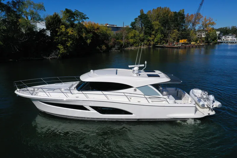 Slide: The Image of 2025 Riviera 465 SUV luxury yacht cruising on a serene river. - 3