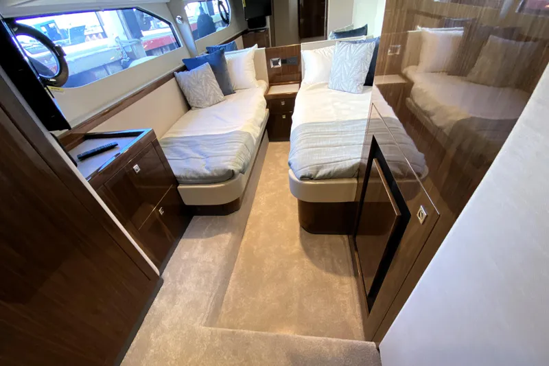 Slide: The Image of Luxurious interior of 2025 Riviera 465 SUV yacht with twin beds and elegant wood finish. - 33