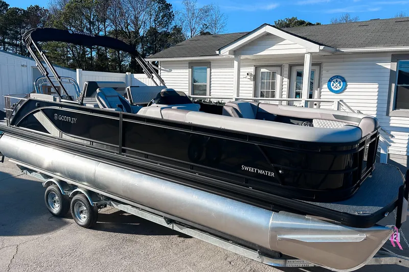 Slide: The Image of 2025 Godfrey Sweetwater 24' Tritoon with Suzuki engine, showcased indoors. - 1