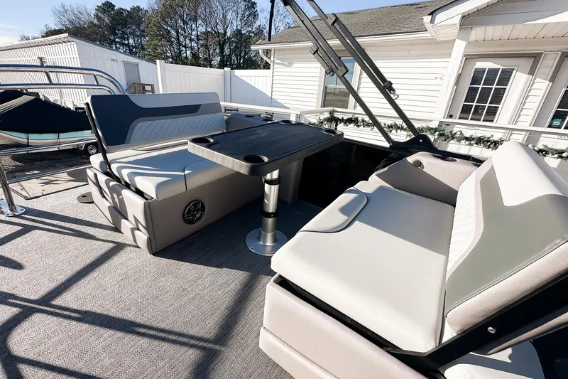 Slide: The Image of 2025 Godfrey Sweetwater 24' Tritoon interior with steering console and lounge seating. - 10