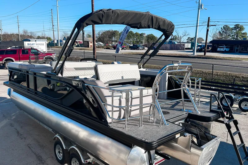 Slide: The Image of 2025 Godfrey Sweetwater 24' Drop Table Lounge Tritoon, sleek design, parked on trailer. - 26