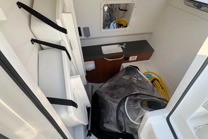 Slide: The Image of 2025 Pursuit S 288 Sport boat interior with storage, sink, and equipment. - 11