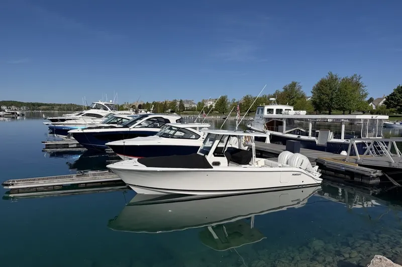 Slide: The Image of 2025 Pursuit S 288 Sport boat docked in a serene marina under clear blue skies. - 1