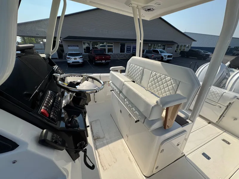 Slide: The Image of 2025 Pursuit S 288 Sport boat interior with steering wheel and cushioned seating. - 7