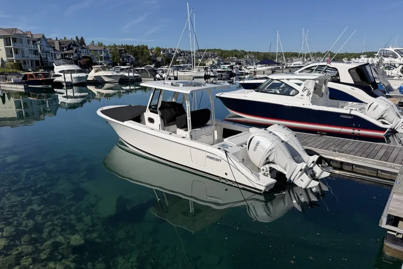 Slide: The Image of 2025 Pursuit S 288 Sport boat docked in a marina with clear water. - 2