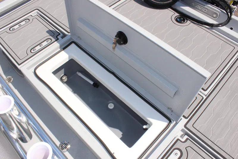 Slide: The Image of Avid 23 FSX 2025 boat storage compartment with key lock and cup holders. - 16