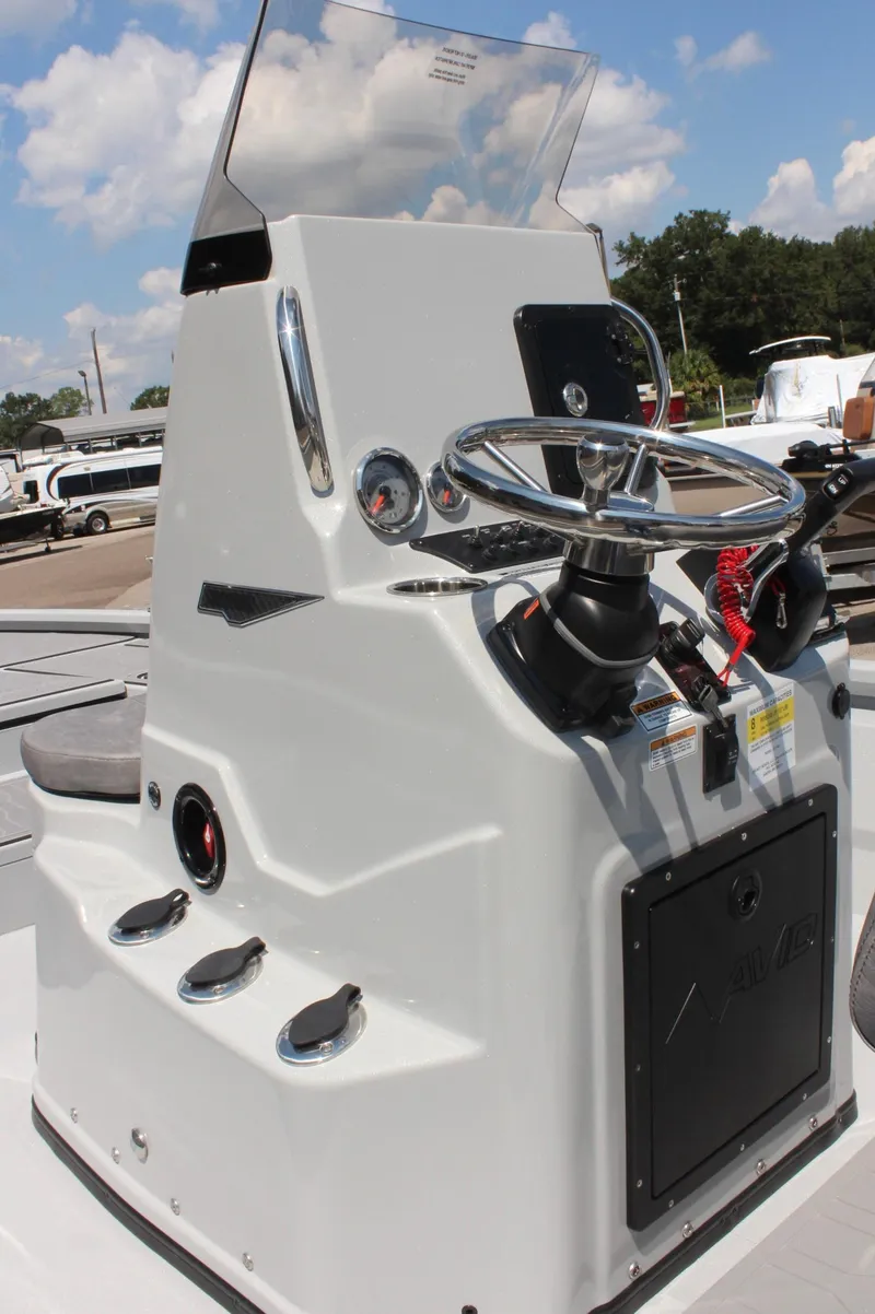Slide: The Image of 2025 Avid 23 FSX boat console with steering wheel and controls, under a clear blue sky. - 21