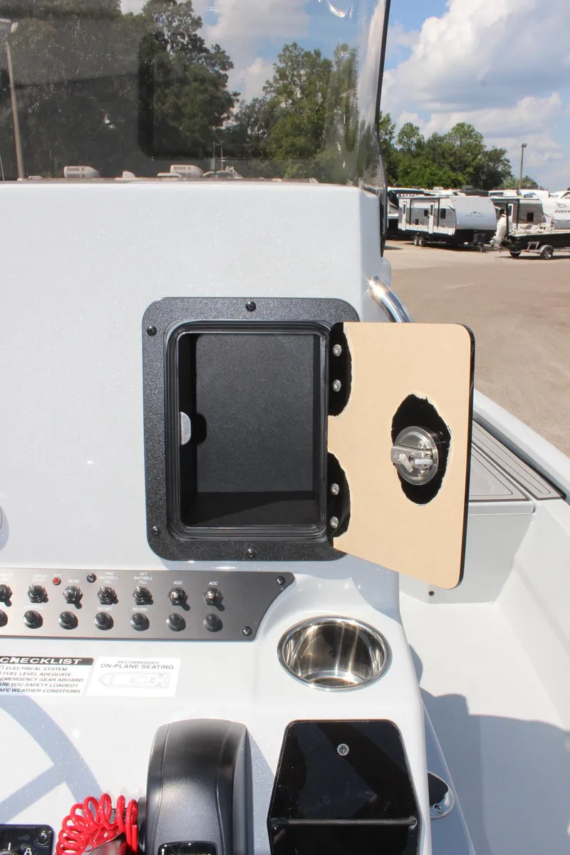 Slide: The Image of 2025 Avid 23 FSX boat dashboard with open storage compartment and control panel. - 23