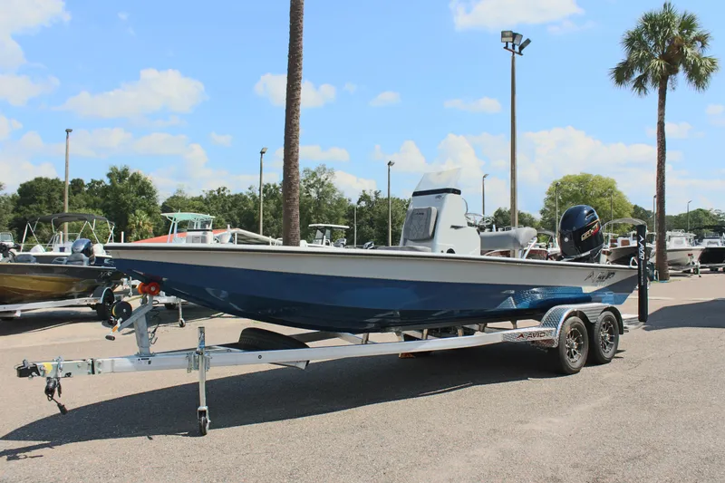 Slide: The Image of 2025 Avid 23 FSX boat on trailer in sunny outdoor setting. - 3