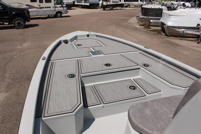 Slide: The Image of 2025 Avid 23 FSX boat deck with storage compartments in a marina setting. - 30