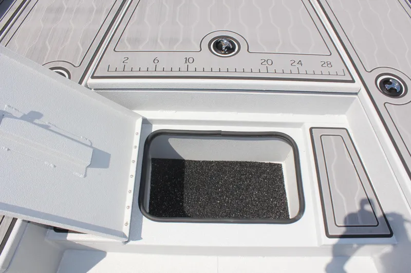 Slide: The Image of 2025 Avid 23 FSX boat deck with open storage compartment and measurement markings. - 32