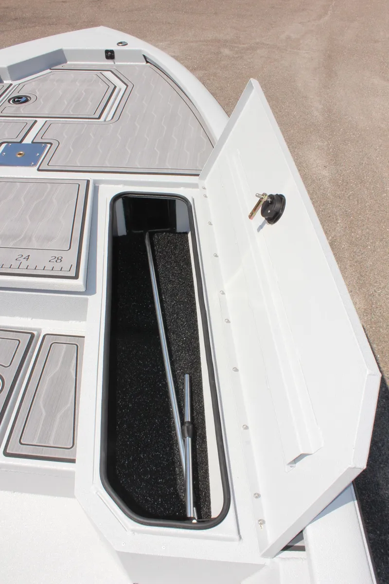 Slide: The Image of Avid 23 FSX 2025 boat storage compartment with open hatch and secure lock. - 33