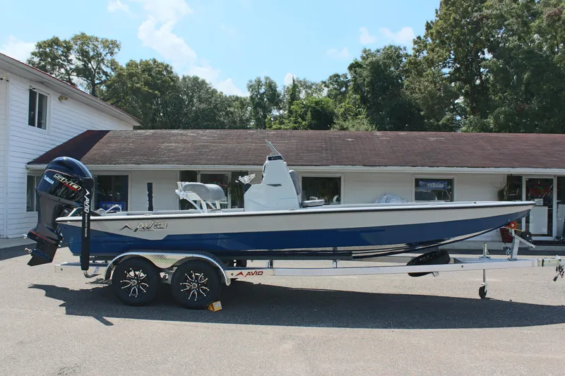 Slide: The Image of 2025 Avid 23 FSX boat on trailer, parked outside a building. - 6