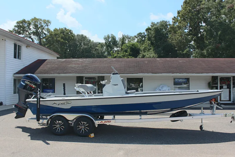 Slide: The Image of 2025 Avid 23 FSX boat on trailer, parked outside a building. - 7