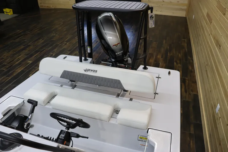 Slide: The Image of 2025 Hewes 16 Redfisher boat interior with Yamaha outboard motor in wooden showroom. - 11